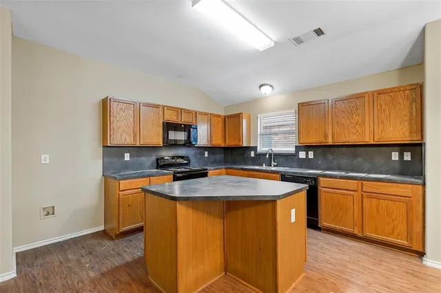 a kitchen with stainless steel appliances granite countertop wooden cabinets sink and stove