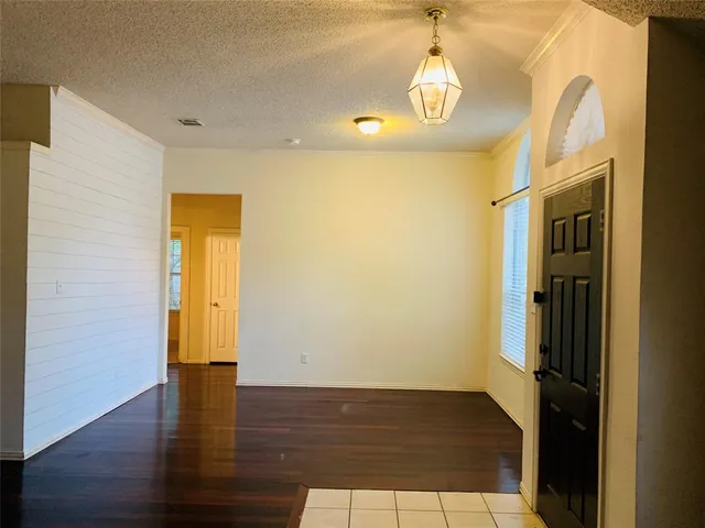 a view of empty room with wooden floor and windows