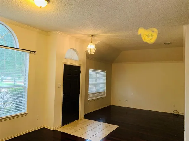 a view of a bedroom with wooden floor and windows