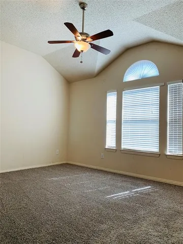 an empty room with a ceiling fan and window