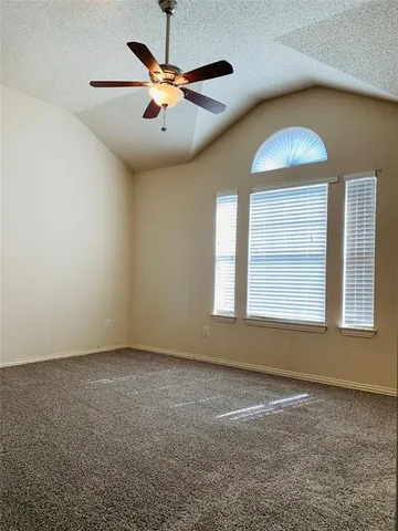 an empty room with a window and ceiling fan
