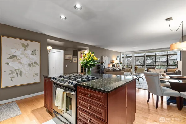 a kitchen with stainless steel appliances granite countertop a stove and a dining table