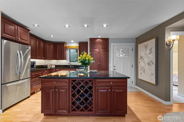 a kitchen with stainless steel appliances granite countertop a refrigerator and a stove
