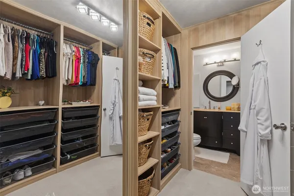 a view of walk in closet with clothes and shoes