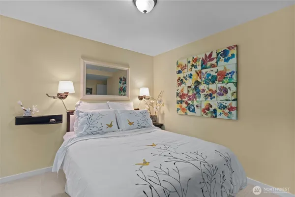a bedroom with a bed and a painting on the wall