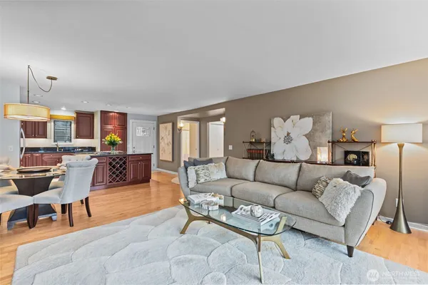 a living room with furniture kitchen view and a window