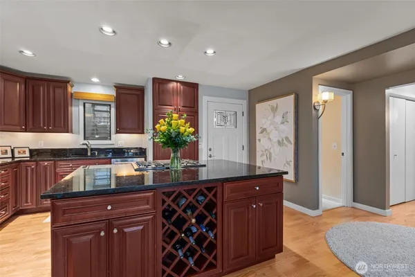 a kitchen with stainless steel appliances granite countertop a sink and a refrigerator