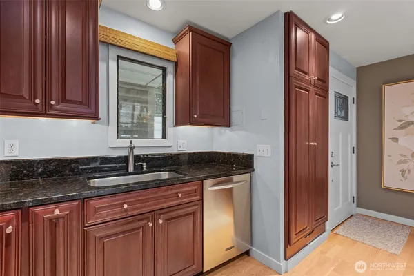 a kitchen with granite countertop cabinets sink and window
