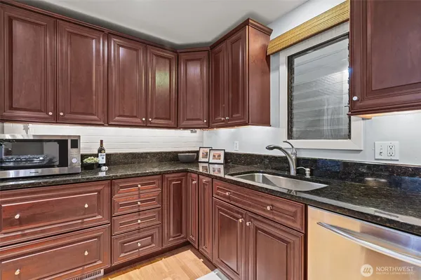 a kitchen with granite countertop a sink and cabinets