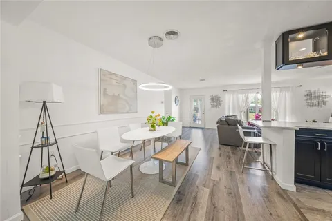 a view of a dining room with furniture a rug and wooden floor