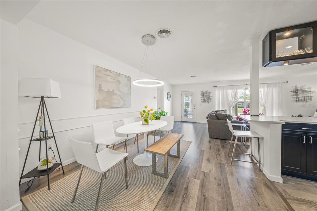 2427 Tulip Street Sarasota, FL 34239 - Photo 13 of 39 a view of a dining room with furniture a rug and wooden floor