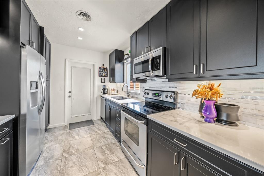 2427 Tulip Street Sarasota, FL 34239 - Photo 8 of 39 a kitchen with stainless steel appliances granite countertop a refrigerator and a stove top oven