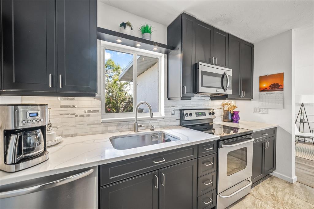 2427 Tulip Street Sarasota, FL 34239 - Photo 9 of 39 a kitchen with a sink stove and microwave