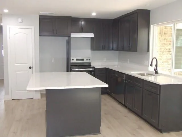 a kitchen with a sink cabinets and window