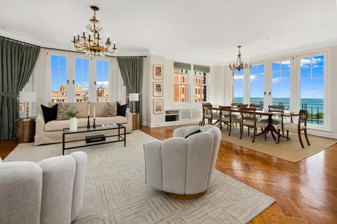 a living room with furniture a chandelier and a dining table