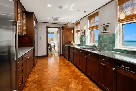 a large kitchen with stainless steel appliances granite countertop a large counter top and a sink
