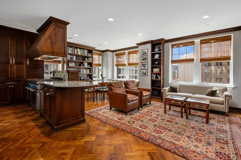 a living room with furniture large window and wooden floor