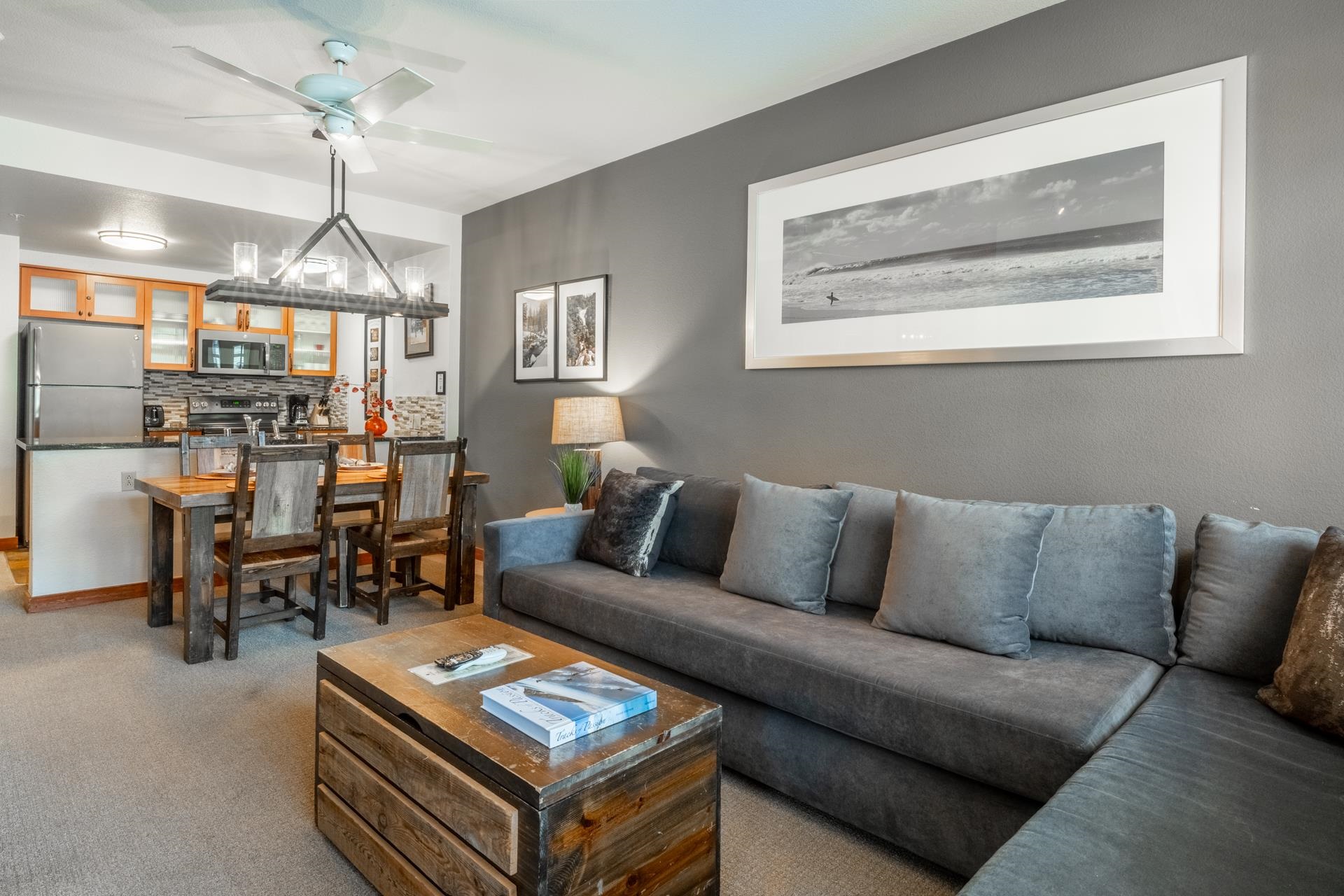 6201 Minaret Road, Unit 2328 Mammoth Lakes, CA 93546 - Photo 14 of 23 Open-concept living space featuring wood-finish cabinetry, stainless steel appliances, and a dining area with a linear chandelier