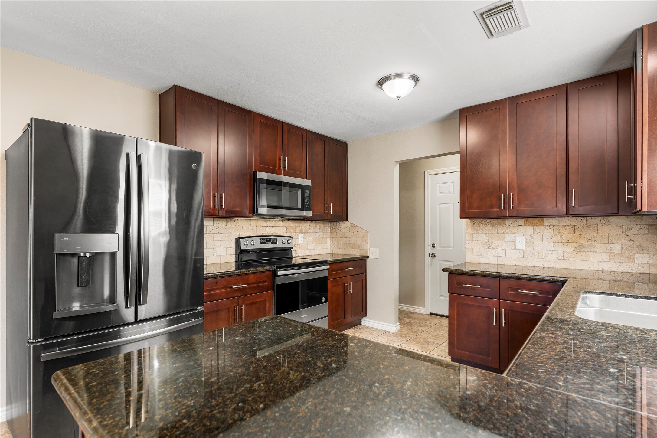 2007 Fernspray Lane Houston, TX 77084 - Photo 12 of 34 a kitchen with stainless steel appliances granite countertop a refrigerator and a stove top oven