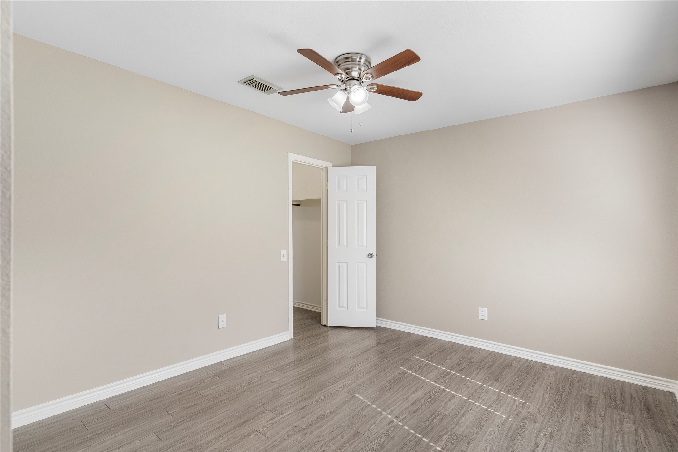 2007 Fernspray Lane Houston, TX 77084 - Photo 27 of 34 an empty room with wooden floor and ceiling fan