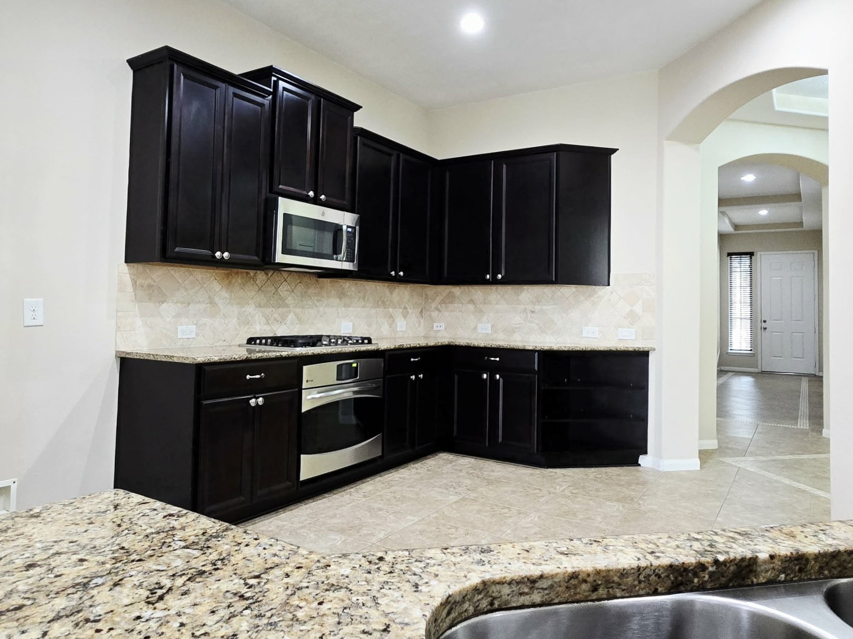 14015 Hailey Springs Lane Humble, TX 77396 - Photo 21 of 34 a kitchen with stainless steel appliances granite countertop wooden cabinets a stove top oven and granite counter top