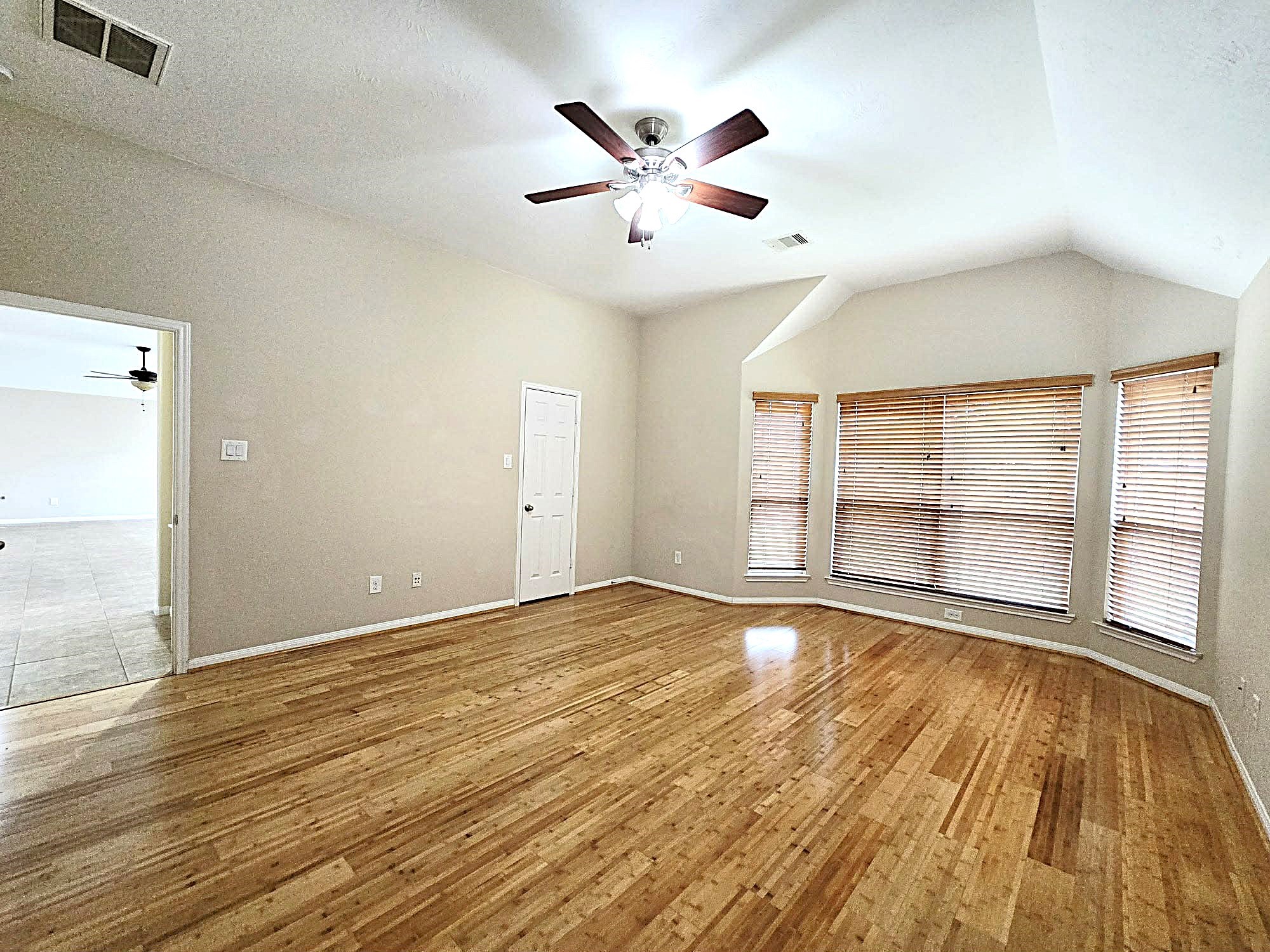 14015 Hailey Springs Lane Humble, TX 77396 - Photo 27 of 34 an empty room with wooden floor and windows