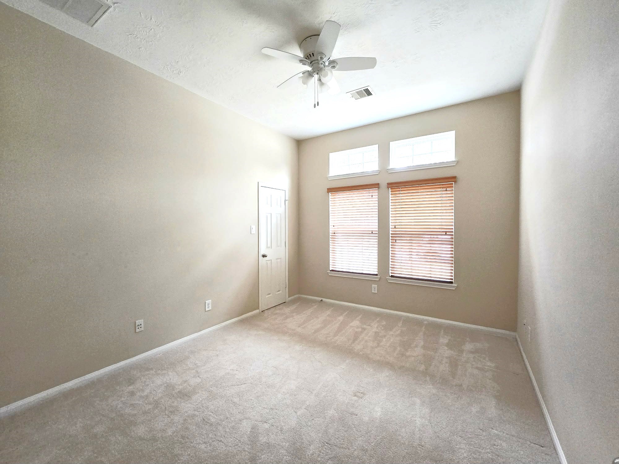 14015 Hailey Springs Lane Humble, TX 77396 - Photo 5 of 34 an empty room with a chandelier fan and windows