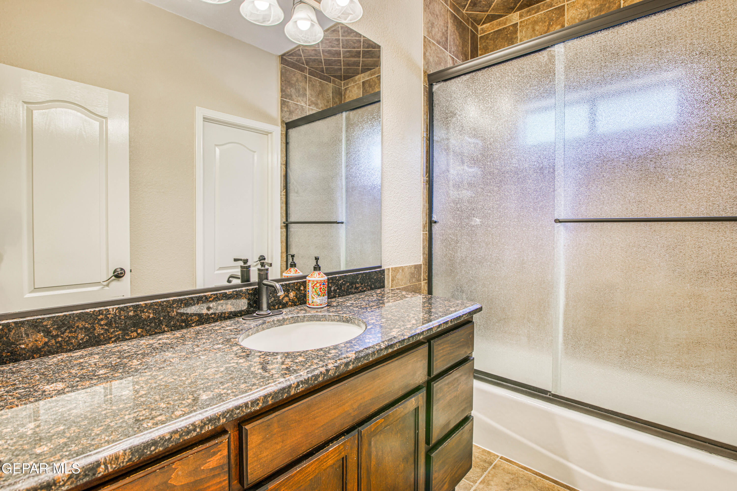 617 Wallace Road Anthony, NM 88021 - Photo 30 of 87 a bathroom with a granite countertop shower sink and mirror