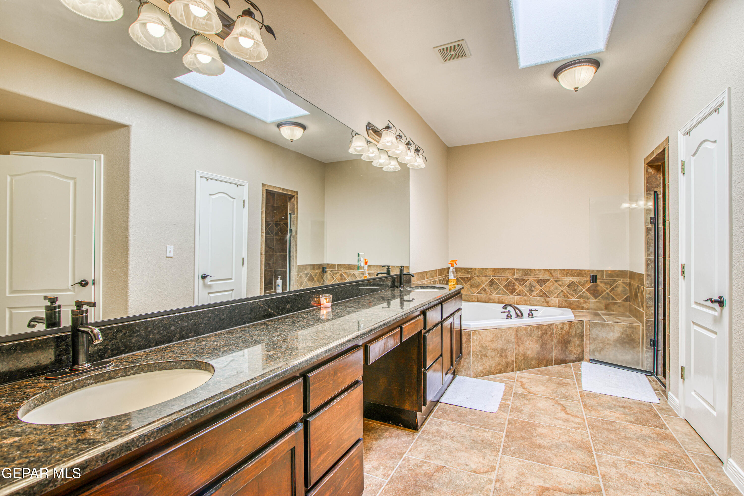 617 Wallace Road Anthony, NM 88021 - Photo 41 of 87 a spacious bathroom with a granite countertop sink a mirror and a bathtub