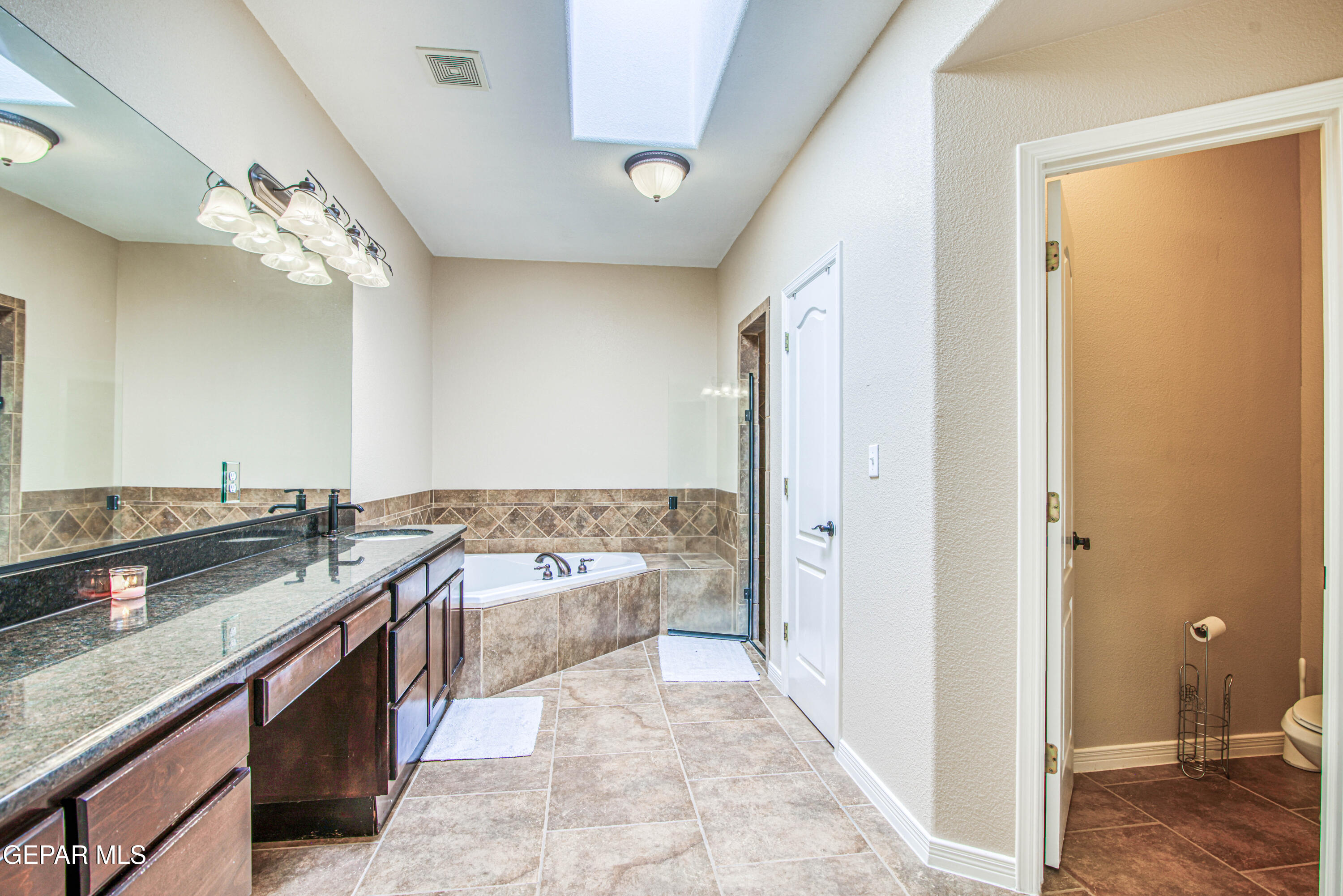 617 Wallace Road Anthony, NM 88021 - Photo 45 of 87 a large bathroom with a granite countertop tub a double vanity sink and a mirror
