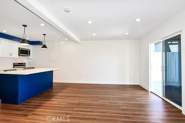 a view of kitchen with wooden floor and electronic appliances