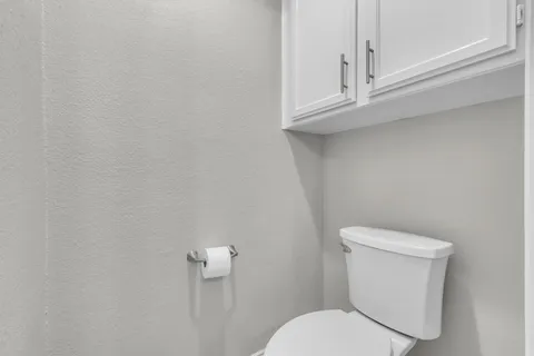 a white toilet sitting next to a window
