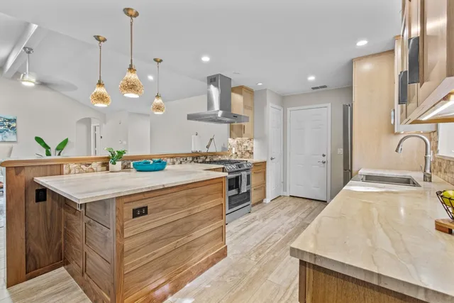a kitchen with kitchen island a sink and a stove