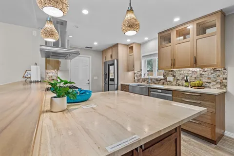 a large kitchen with kitchen island a sink stainless steel appliances and cabinets