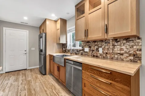 a kitchen with stainless steel appliances granite countertop a sink and cabinets