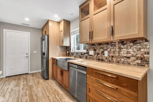 a kitchen with stainless steel appliances granite countertop a sink and cabinets