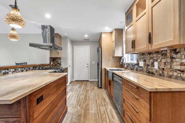 a kitchen with stainless steel appliances granite countertop a sink stove and refrigerator