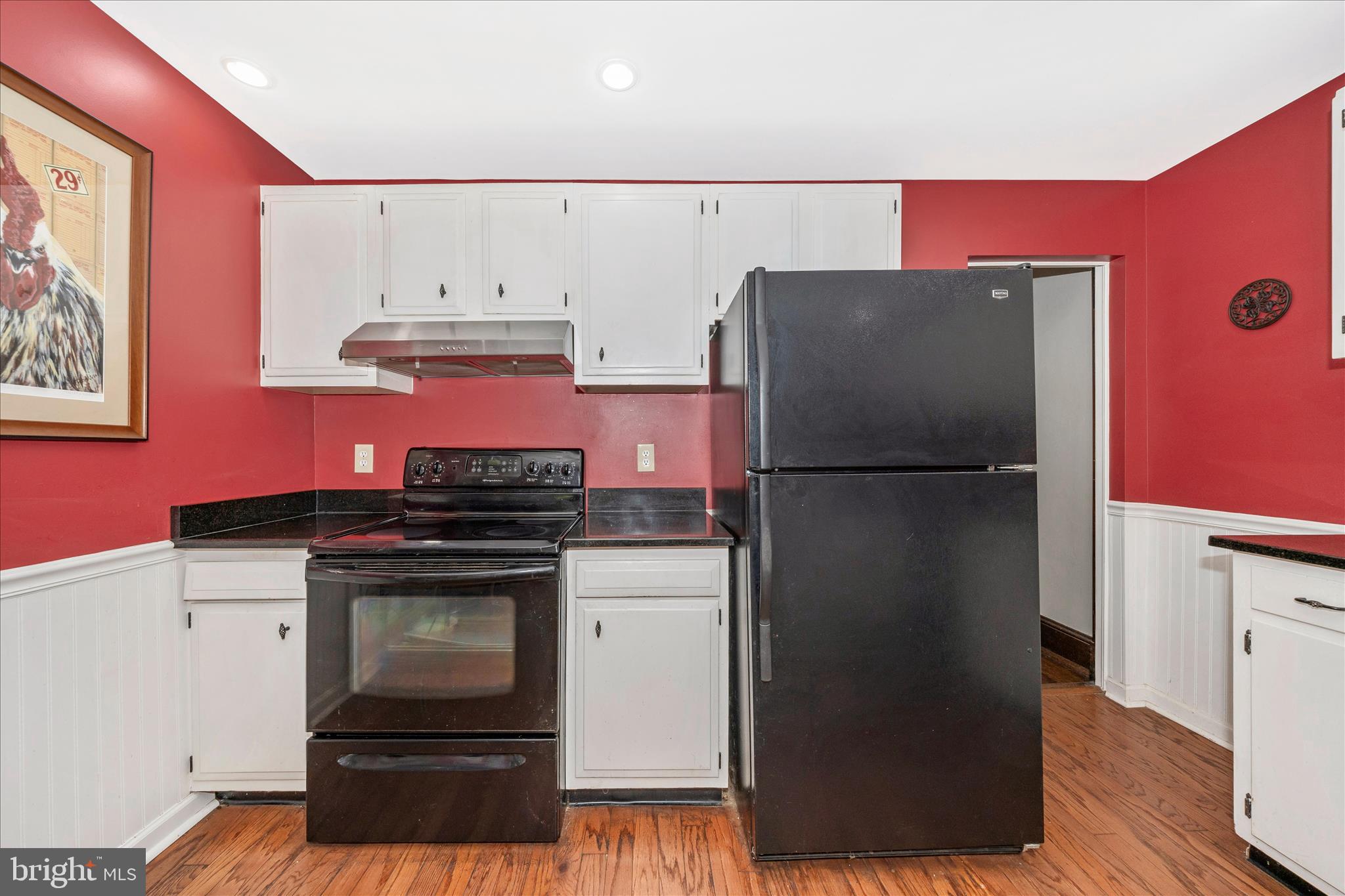 24 East 8th Street Frederick, MD 21701 - Photo 22 of 51 a kitchen with a refrigerator stove and wooden floor