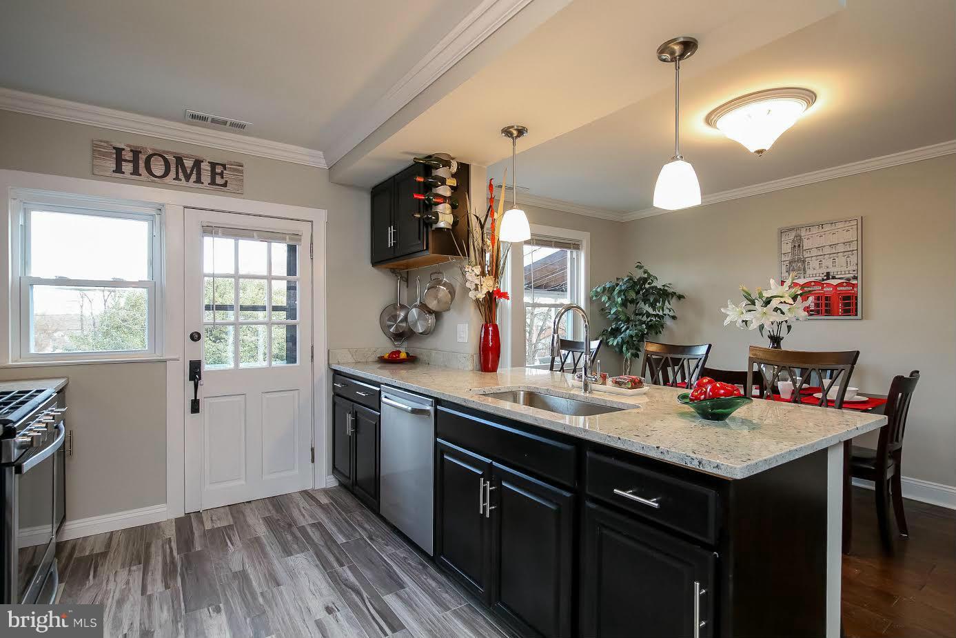 5405 Hillen Road Baltimore, MD 21239 - Photo 9 of 27 a kitchen with a sink dishwasher stove and wooden floor