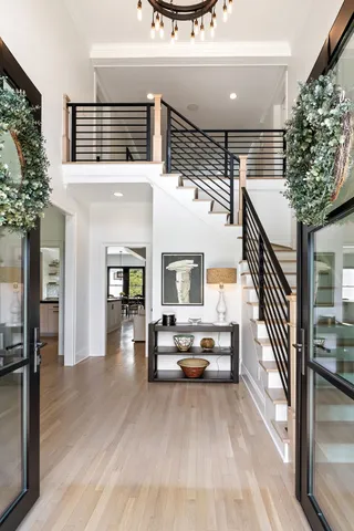 a view of a hallway with wooden floor and staircase