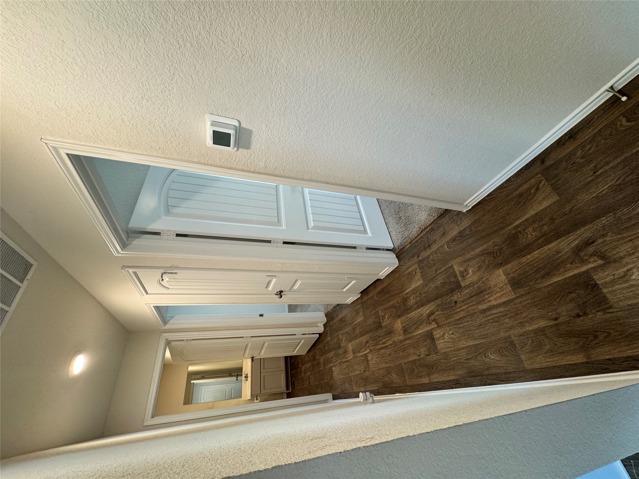 11820 Rush Lane Elgin, TX 78621 - Photo 6 of 31 A lengthy hallway with rich wood-look flooring connects various rooms.