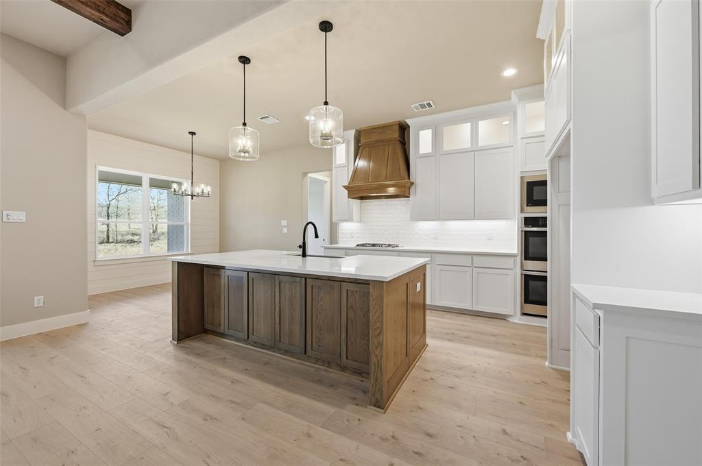 1053 Llano Way Poolville, TX 76487 - Photo 13 of 40 a large kitchen with kitchen island a sink stainless steel appliances and cabinets