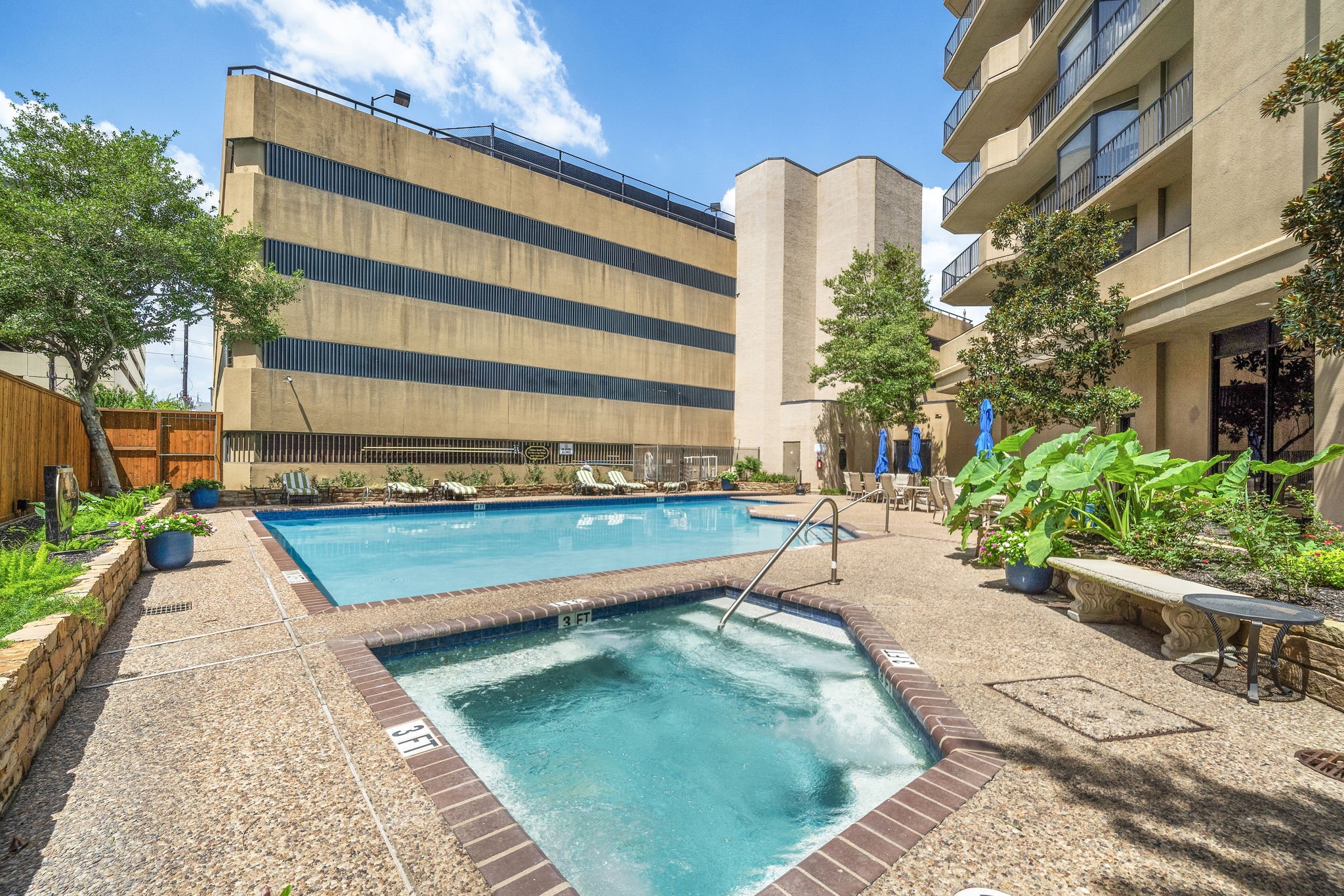 3350 McCue Road, Unit 2402 Houston, TX 77056 - Photo 45 of 49 Unwind by the pristine swimming pool and heated spa, framed by an expansive sundeck with tropical potted plants. Dedicated lounge chairs and shaded seating areas create a private resort-style oasis for effortless outdoor relaxation in the heart of Uptown.