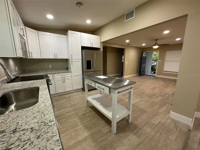 a kitchen with stainless steel appliances granite countertop a sink stove and refrigerator