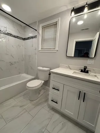 a bathroom with a double vanity sink mirror and toilet