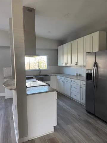 a kitchen with kitchen island granite countertop a sink stove and refrigerator