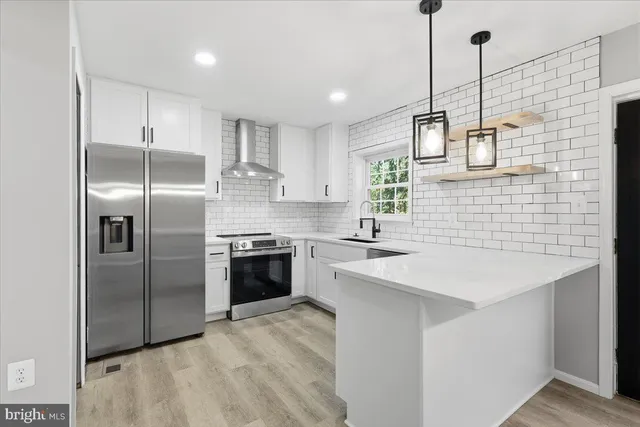 a kitchen with stainless steel appliances granite countertop a sink a refrigerator and a stove