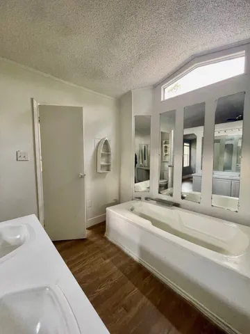 a bedroom with a bed and a large mirror