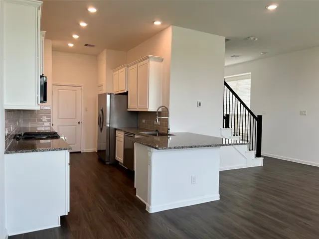a kitchen with stainless steel appliances granite countertop a stove a sink and a refrigerator