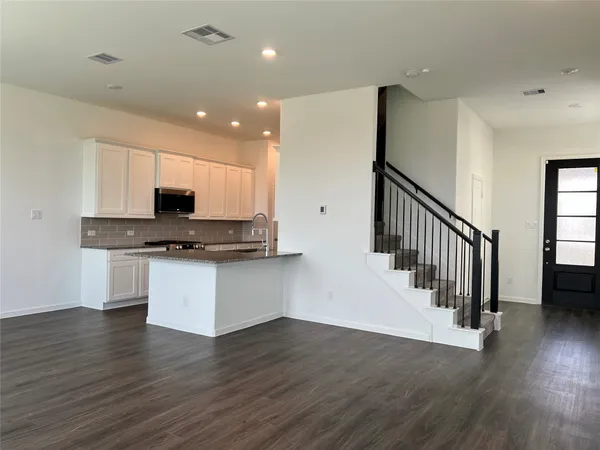 a view of kitchen with stainless steel appliances granite countertop a stove a sink and a wooden floors